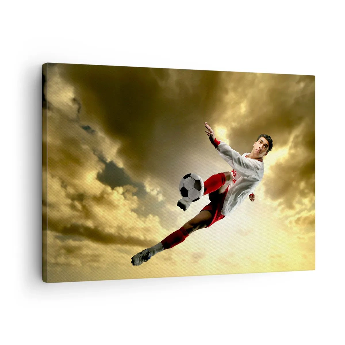 Obraz na plátne - Futbalista v dynamickom výskoku kope loptu proti oblohe - 70x50cm - Futbalové nebo - Moderná nástenná dekorácia do obývacej izby a spálne ARTTOR