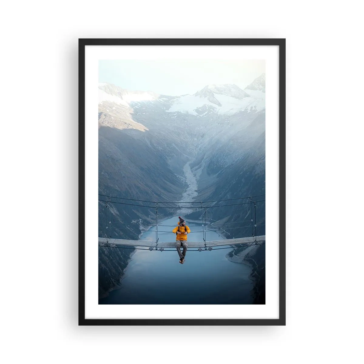 Plagát v čiernom ráme - Osoba v žltej bunde sediaca na visutom moste nad údolím - 50x70cm - Očarený v spánku - Moderná nástenná dekorácia do obývacej izby a spálne ARTTOR