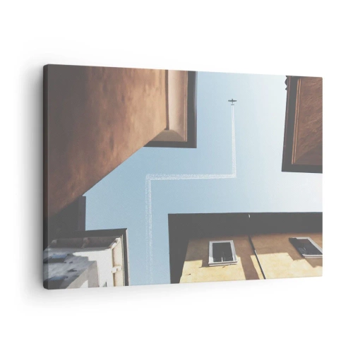 Obraz na plátne - Pohľad na lietadlo a jeho stopu na oblohe z pouličnej perspektívy - 70x50cm - Nad mestským labyrintom - Moderná nástenná dekorácia do obývacej izby a spálne ARTTOR