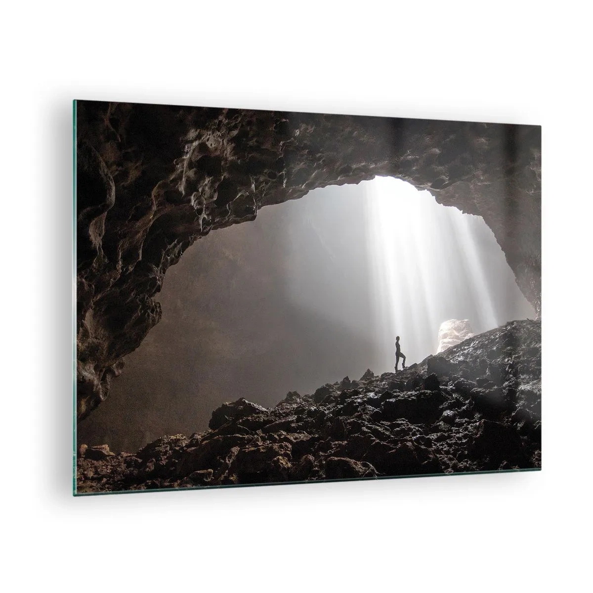 Obraz na skle - Postava v jaskyni osvetlenej lúčmi svetla, obklopená tmavými skalami - 70x50cm - Svetelná jaskyňa - Moderná nástenná dekorácia do obývacej izby a spálne ARTTOR