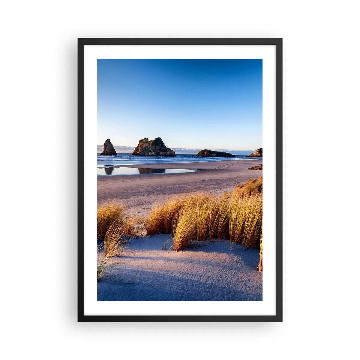 Plagát v čiernom ráme - Malebná pláž s trávou a skalami na pozadí pokojného oceánu - 50x70cm - Pre hľadačov pokoja - Moderná nástenná dekorácia do obývacej izby a spálne ARTTOR