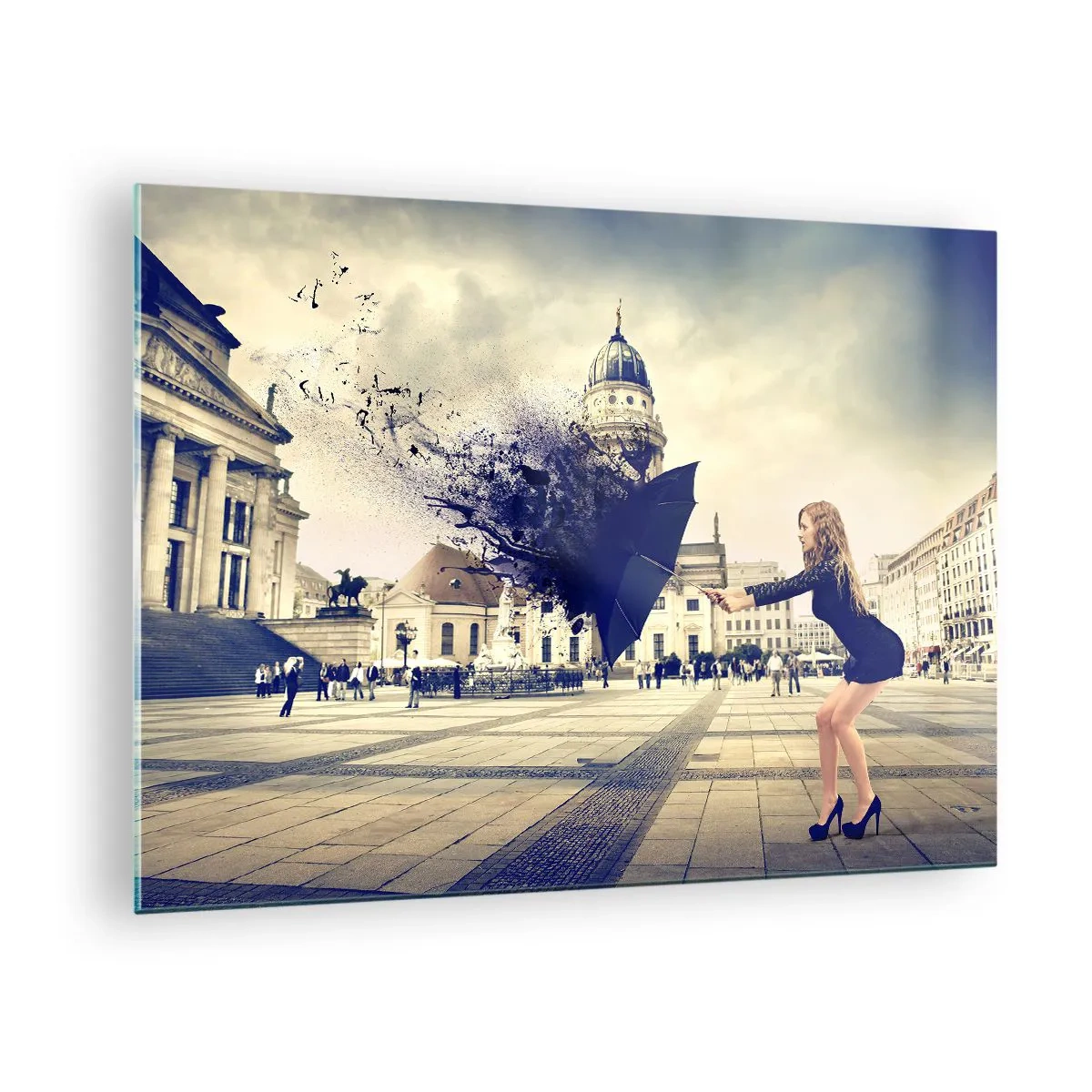 Obraz na skle - Žena s dáždnikom na pozadí mestského námestia v umeleckej kompozícii - 70x50cm - Je taký vietor… - Moderná nástenná dekorácia do obývacej izby a spálne ARTTOR