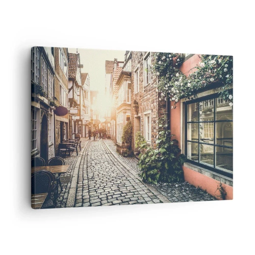 Obraz na plátne - Očarujúca ulica s kamennou dlažbou a kvetmi - 70x50cm - Ružová ulička v ružovej žiare - Moderná nástenná dekorácia do obývacej izby a spálne ARTTOR