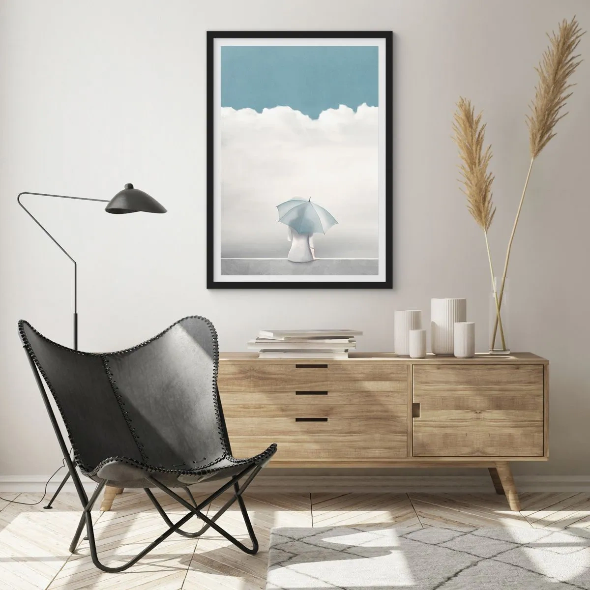 Plagát v čiernom ráme - Postava s dáždnikom sediaca na rímse medzi oblakmi - 50x70cm - Na hrane reality a snov - Moderná nástenná dekorácia do obývacej izby a spálne ARTTOR