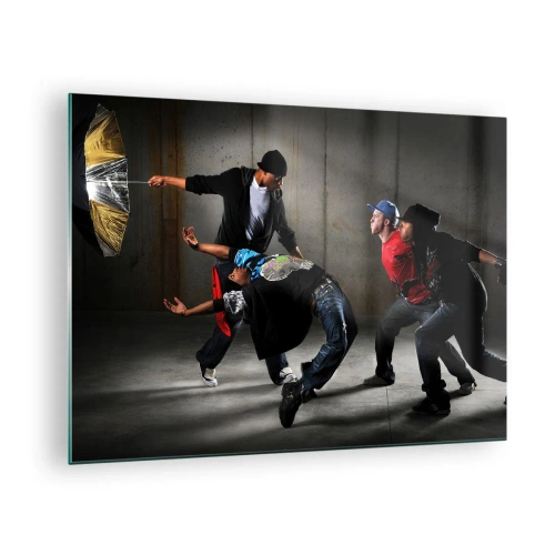 Obraz na skle - Skupina tanečníkov v dynamickej póze na industriálnom pozadí. - 70x50cm - Tancujúci s pouličným vetrom - Moderná nástenná dekorácia do obývacej izby a spálne ARTTOR