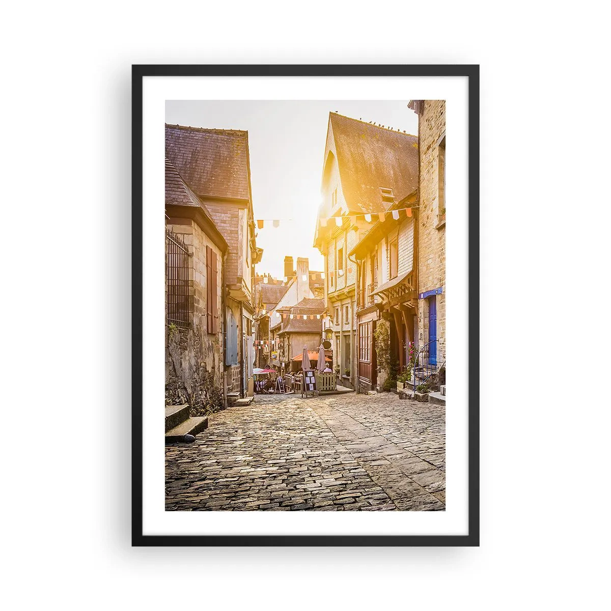 Plagát v čiernom ráme - Očarujúca ulica s činžiakovými domami v lúčoch zapadajúceho slnka - 50x70cm - Biely duch mestečka - Moderná nástenná dekorácia do obývacej izby a spálne ARTTOR