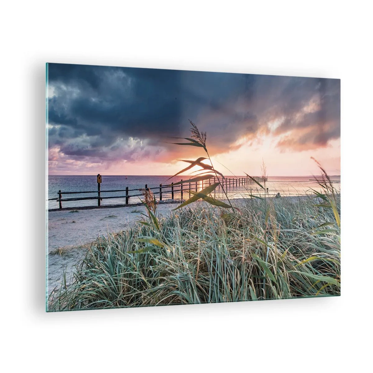 Obraz na skle - Pláž pri západe slnka s výhľadom na mólo, obklopená trávou - 70x50cm - Neodviate vetrom - Moderná nástenná dekorácia do obývacej izby a spálne ARTTOR