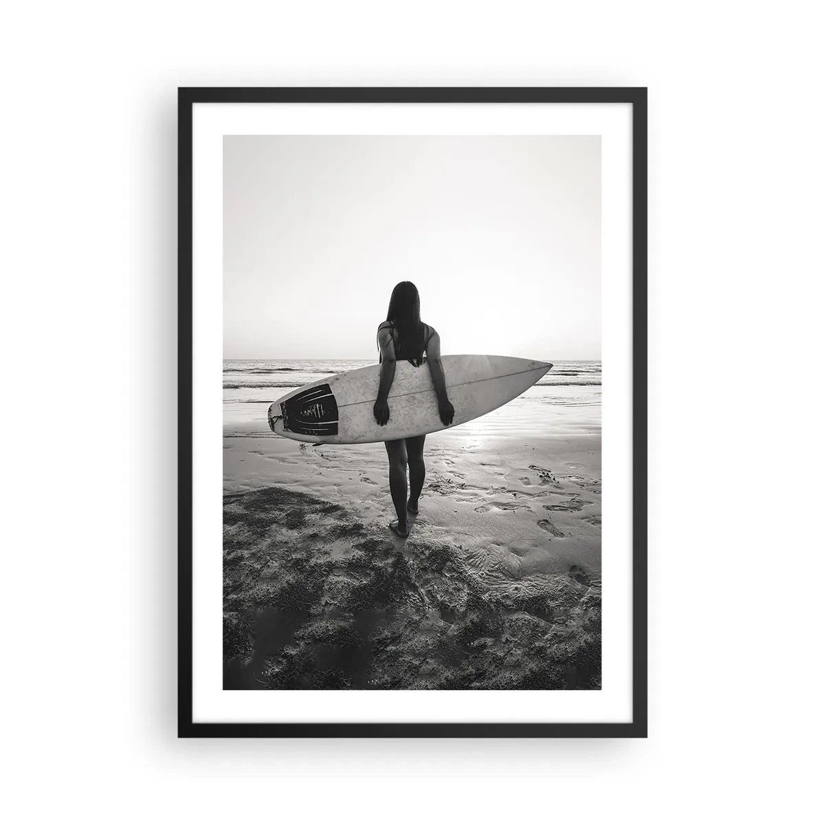Plagát v čiernom ráme - Žena so surfovou doskou na pláži pri západe slnka - 50x70cm - Dcéra morskej vlny - Moderná nástenná dekorácia do obývacej izby a spálne ARTTOR