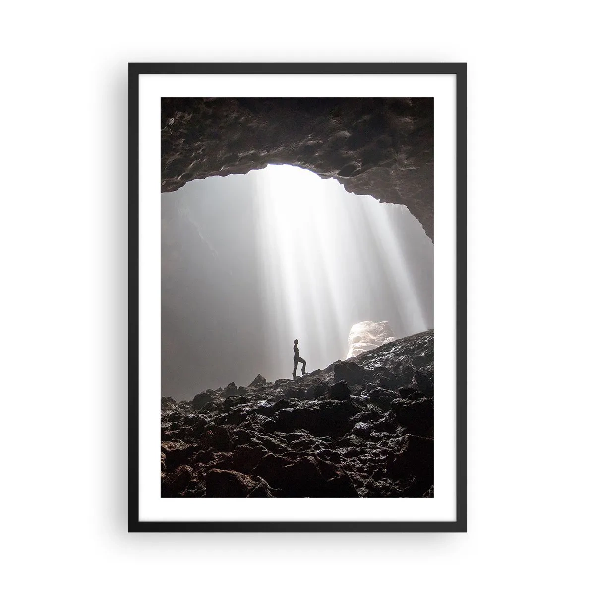 Plagát v čiernom ráme - Postava v jaskyni osvetlenej lúčmi svetla - 50x70cm - Svetelná jaskyňa - Moderná nástenná dekorácia do obývacej izby a spálne ARTTOR