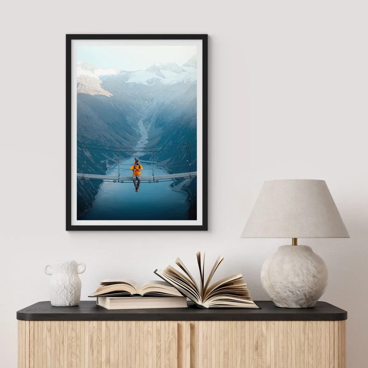 Plagát v čiernom ráme - Osoba v žltej bunde sediaca na visutom moste nad údolím - 50x70cm - Očarený v spánku - Moderná nástenná dekorácia do obývacej izby a spálne ARTTOR