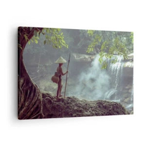 Obraz na plátne - Postava s kopijou pri vodopáde v tropickom lese - 70x50cm - Spriatelený s prírodou - Moderná nástenná dekorácia do obývacej izby a spálne ARTTOR