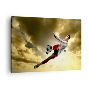 Obraz na plátne - Futbalista v dynamickom výskoku kope loptu proti oblohe - 70x50cm - Futbalové nebo - Moderná nástenná dekorácia do obývacej izby a spálne ARTTOR
