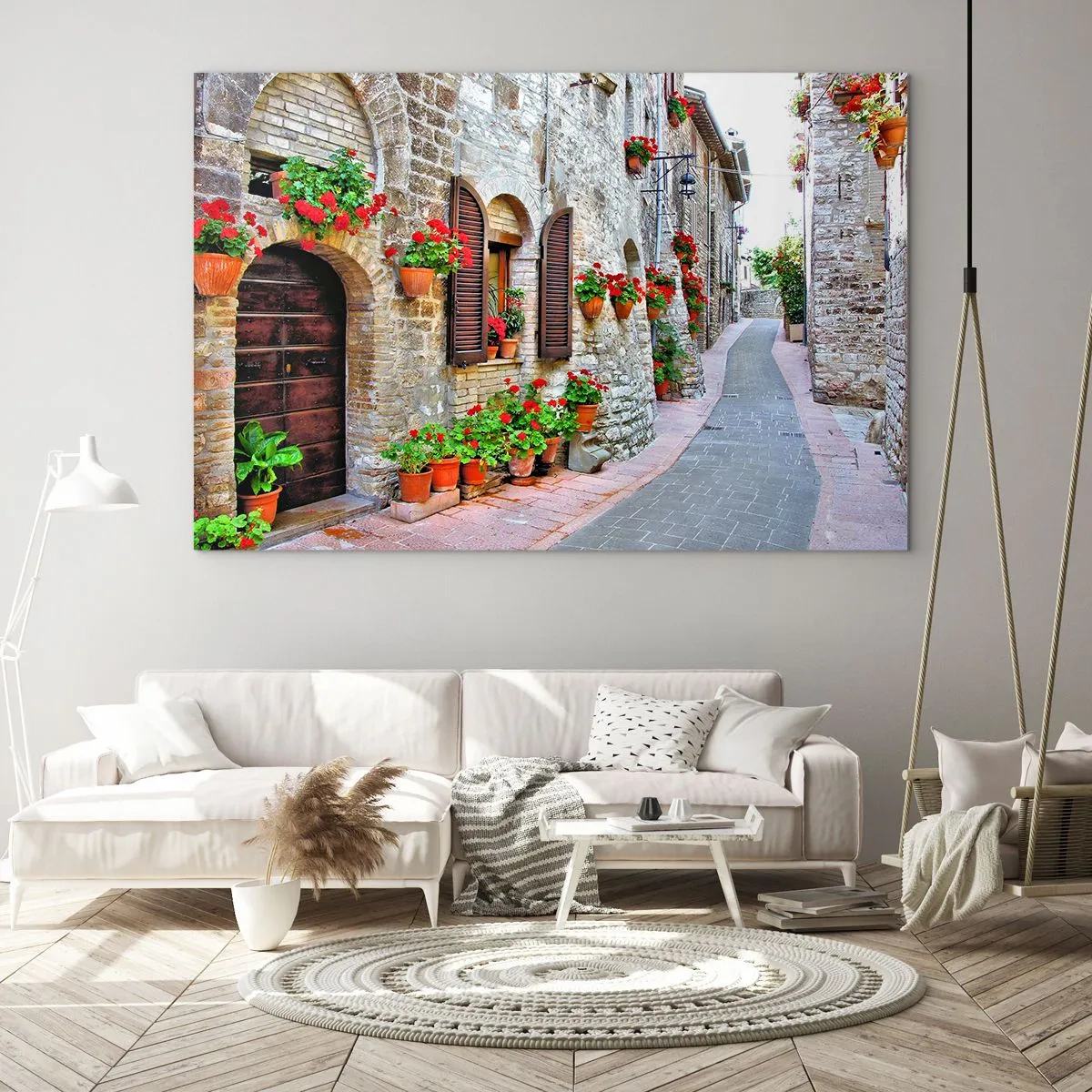 Obraz na skle - Malebná ulica s kamennými múrmi a červenými kvetmi - 70x50cm - Talianska atmosféra - Moderná nástenná dekorácia do obývacej izby a spálne ARTTOR
