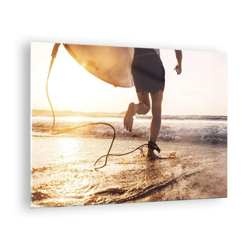 Obraz na skle - Surfer beží so svojou doskou pozdĺž pláže pri západe slnka. - 70x50cm - V ústrety vlne - Moderná nástenná dekorácia do obývacej izby a spálne ARTTOR