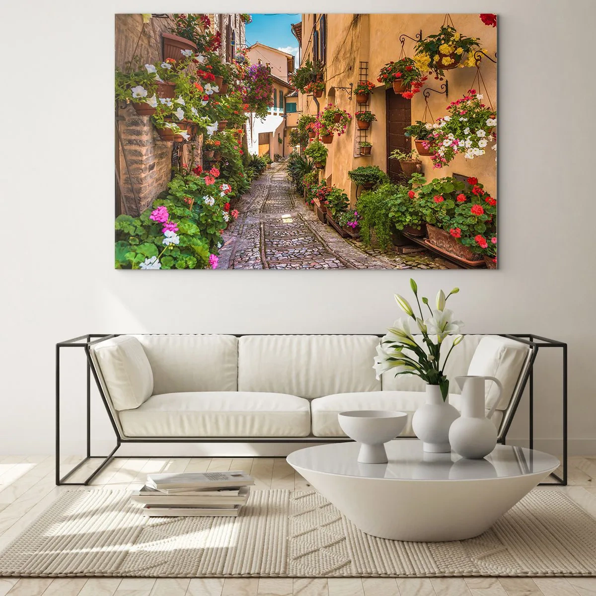Obraz na skle - Očarujúca talianska ulička s kvetmi v kvetináčoch a dláždenou uličkou - 70x50cm - Talianske zákutie - Moderná nástenná dekorácia do obývacej izby a spálne ARTTOR