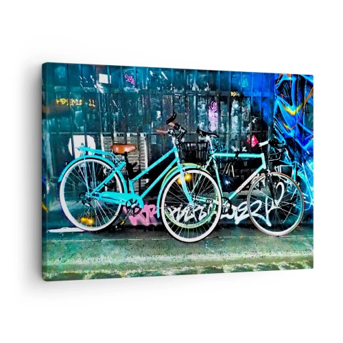 Obraz na plátne - Dva tyrkysové bicykle na pozadí mestského graffiti. - 70x50cm - Mesto volá - Moderná nástenná dekorácia do obývacej izby a spálne ARTTOR